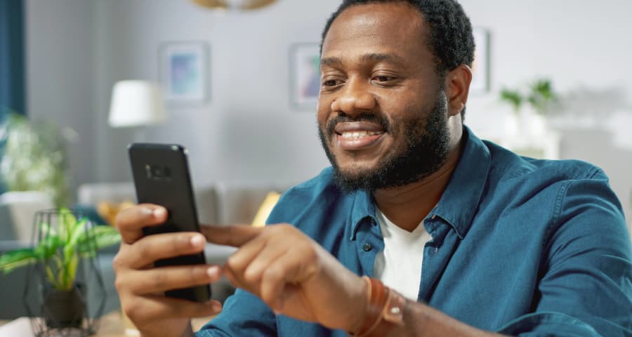 Man sitting down interacting with an app on his phone